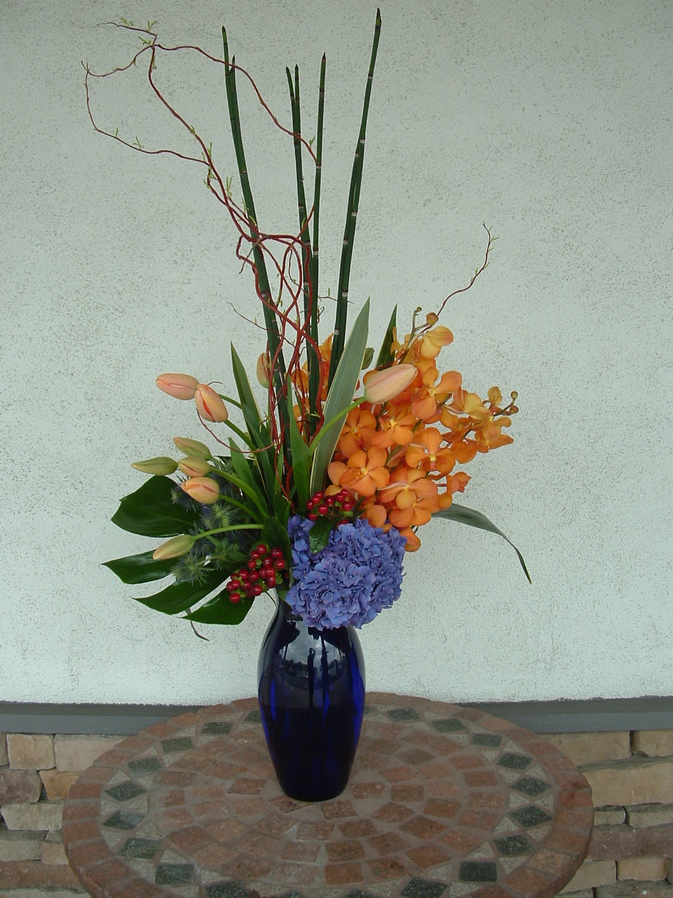Blue vase with peachy and orange flowers 
