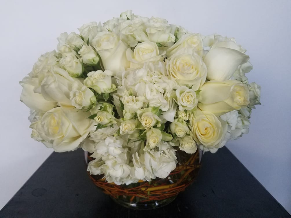 Lush arrangement of all white roses and hydrangea