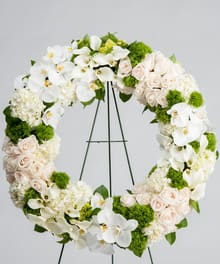 Elegant and exotic memorial wreath in delicate blush, white and green tones.