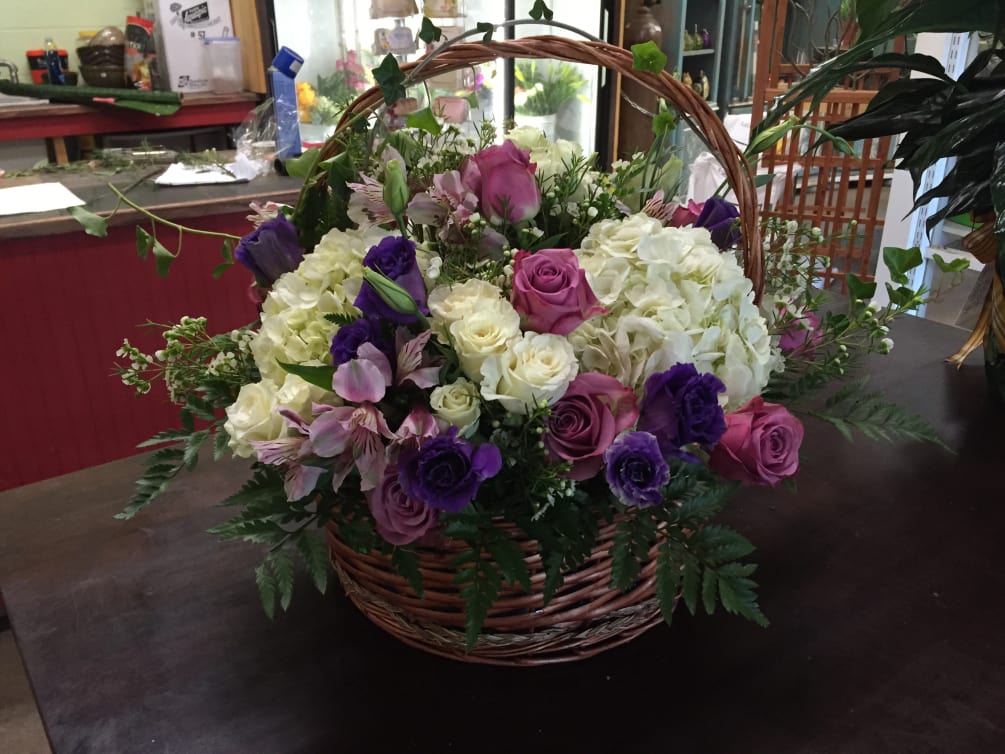 Basket arranged with beautiful hydrangeas, roses, Ivy. 