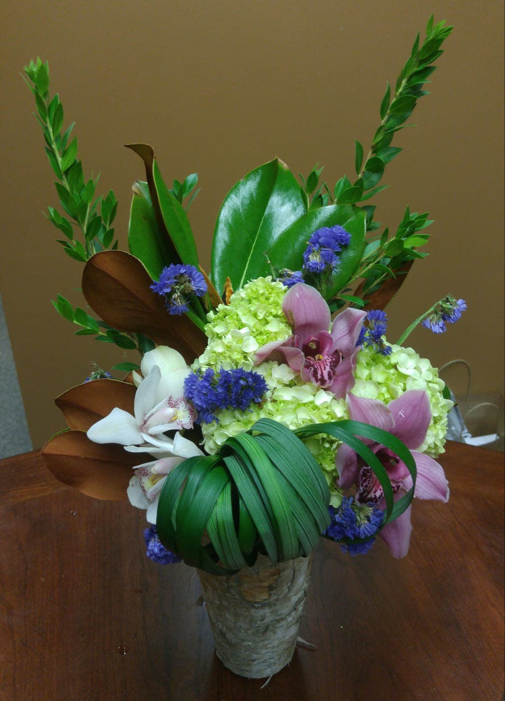 mixed flowers and greens with a birch vase