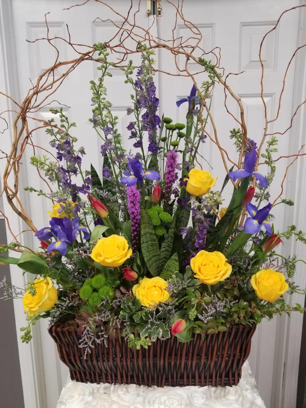 The Willow Garden Arrangement includes Liatris, Delphinium, Roses, Buttons, Tulips, Iris and