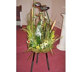 Tripod of 3 golf clubs with outdoorsy floral display. Bring your family