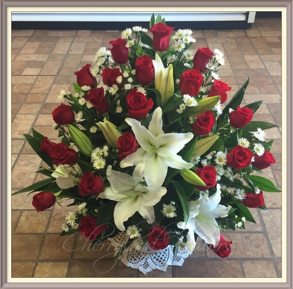 Long stem red roses, white lilies, monte casino, and foliage artfully arranged