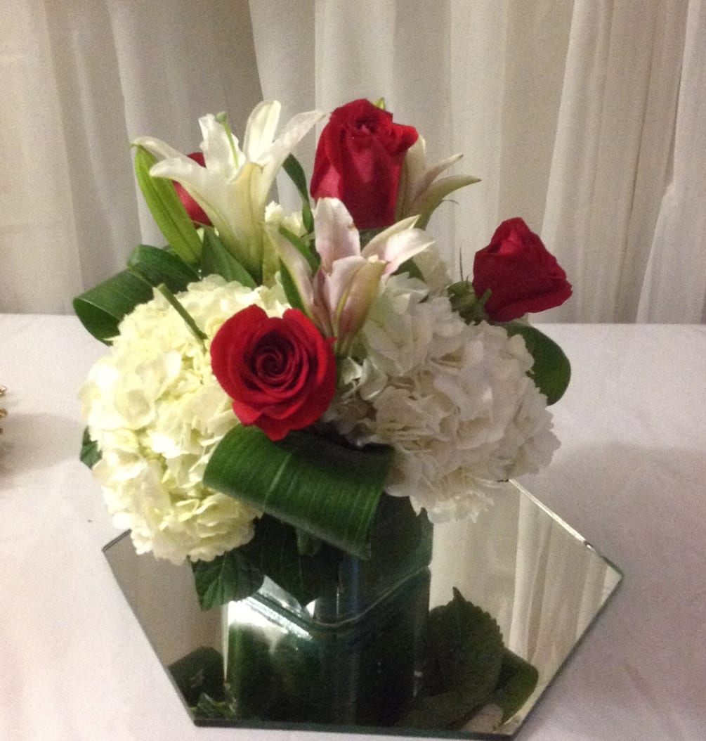 Beautiful red and white flowers design elegantly in a square vase is