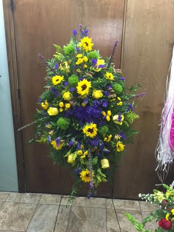 standing easel spray with roses, sunflowers, buttons, statice astro, solidago and liatris.