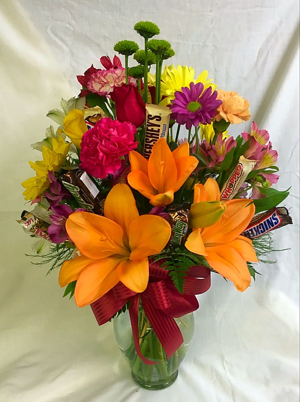 Fresh mixed arrangement in a vase with candy on sticks placed throughout