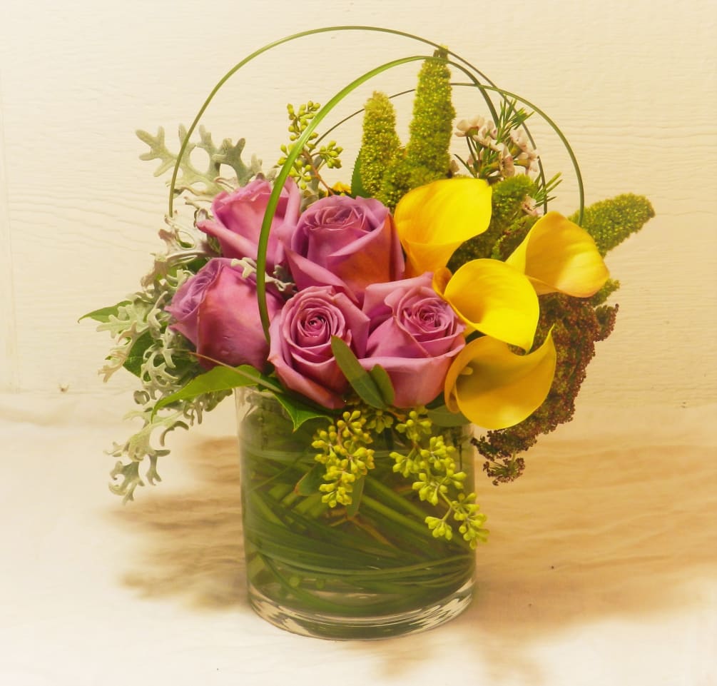 A wonderful mix of yellow Calla lilies, lavender roses, dusty miller, and