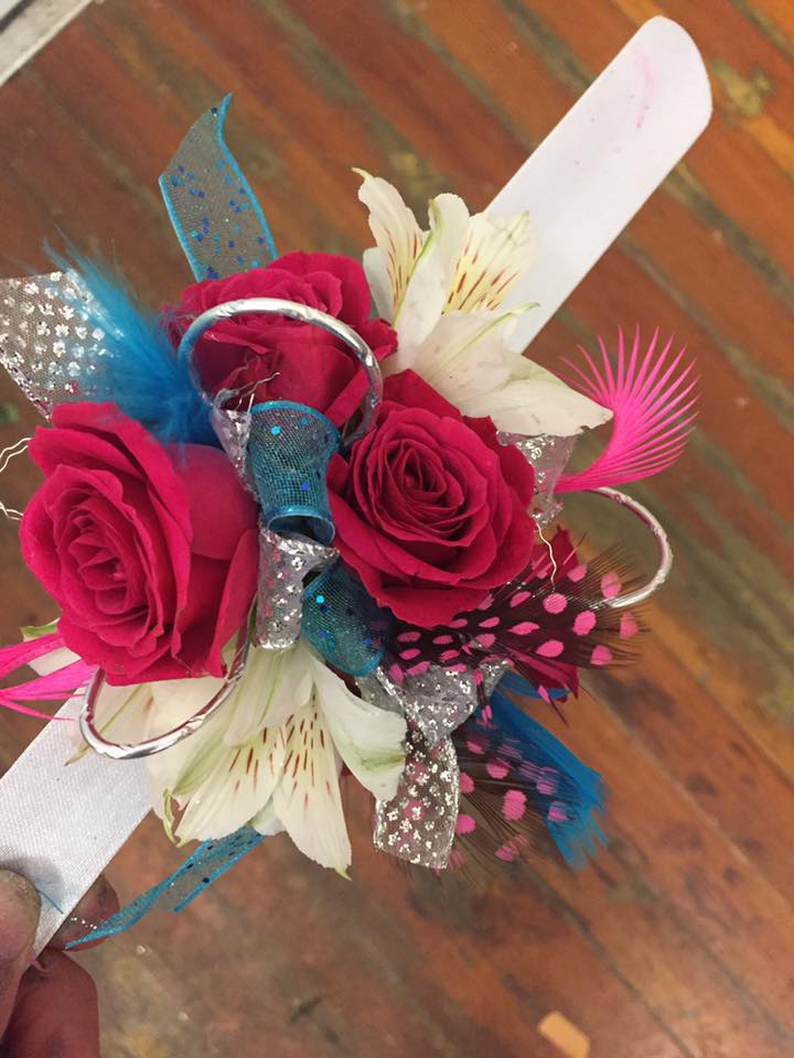 Hot pink roses accented with white alstromaria, turquoise feathers, pink and black