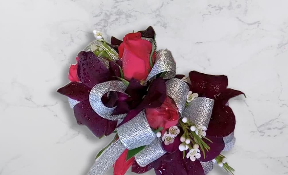 Corsage with hot pink and dark purple roses with white wax flower