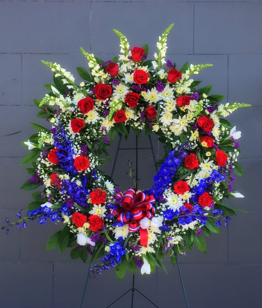Funeral wreath including red, white and blue flowers.