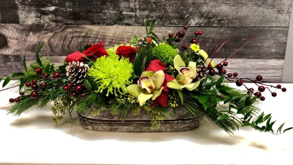 This fresh mix of holiday greens with seasonal flowers and novality accents