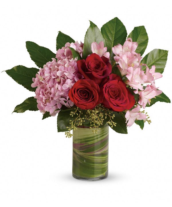 Paradise found! Tropical leaves meet sophisticated hydrangea and rich red roses in