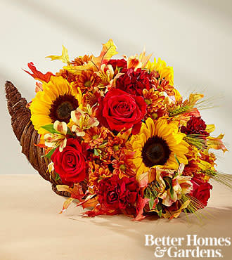 Fall Harvest Cornucopia includes yellow sunflowers; red roses; yellow alstroemeria; orange daisys;