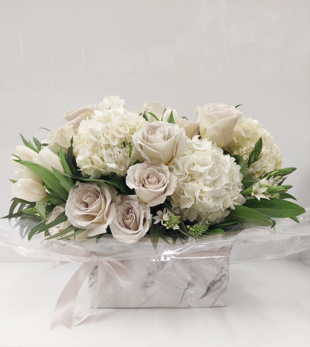 White and lavender arrangement of roses, hydrangeas and tulips.