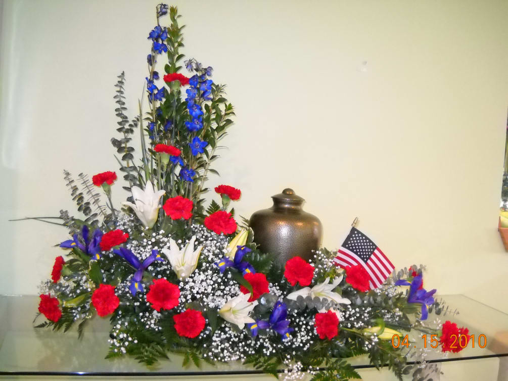 Beautiful patriotic memorial flowers, including delphinium, carnations, lilies, eucalyptus, assorted greens. Can