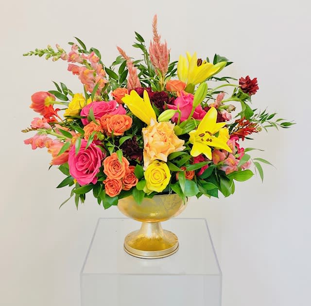 Golden tones highlighted with hot pink accents. Flowers consist of asiatic lilies