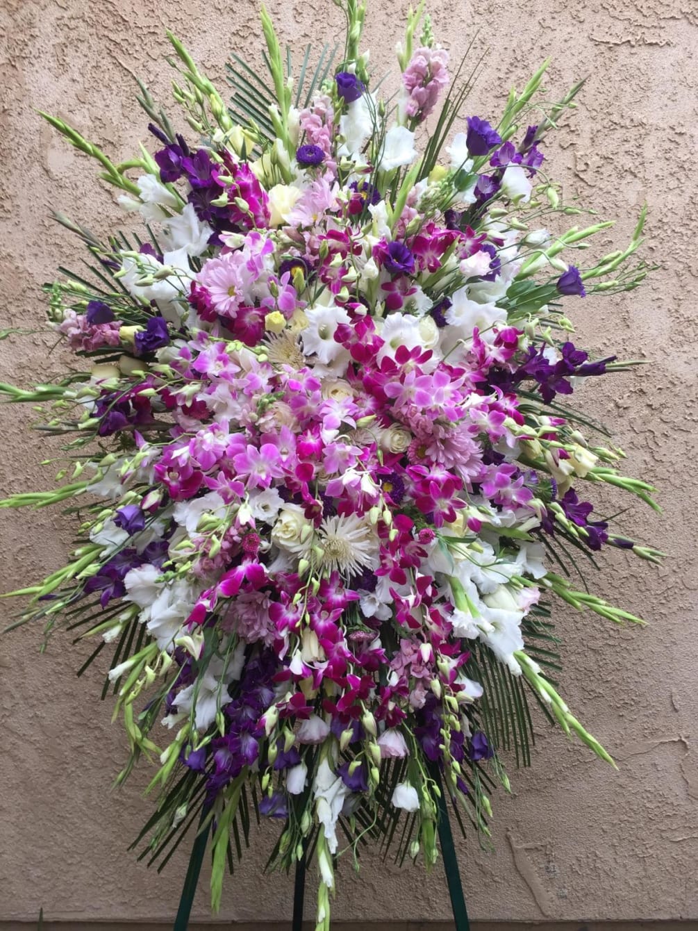 standing spray of orchids, gladiolus and greens.
