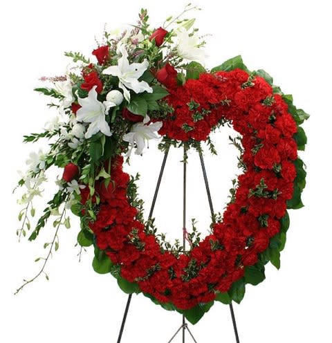 Red heart shaped funeral stand with red carnations and touches of white
