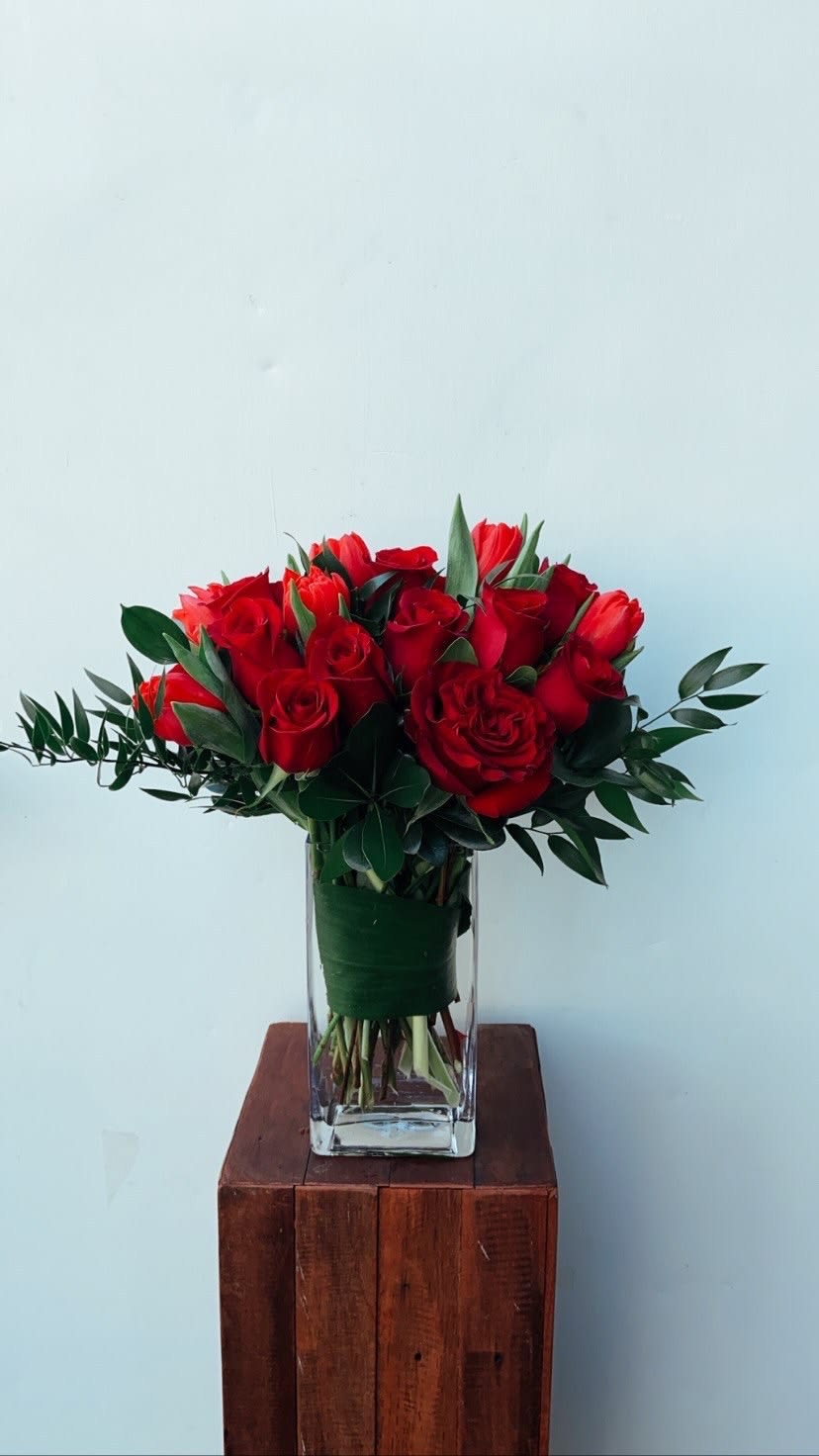 Modern design of red roses and tulips with elegant accents.