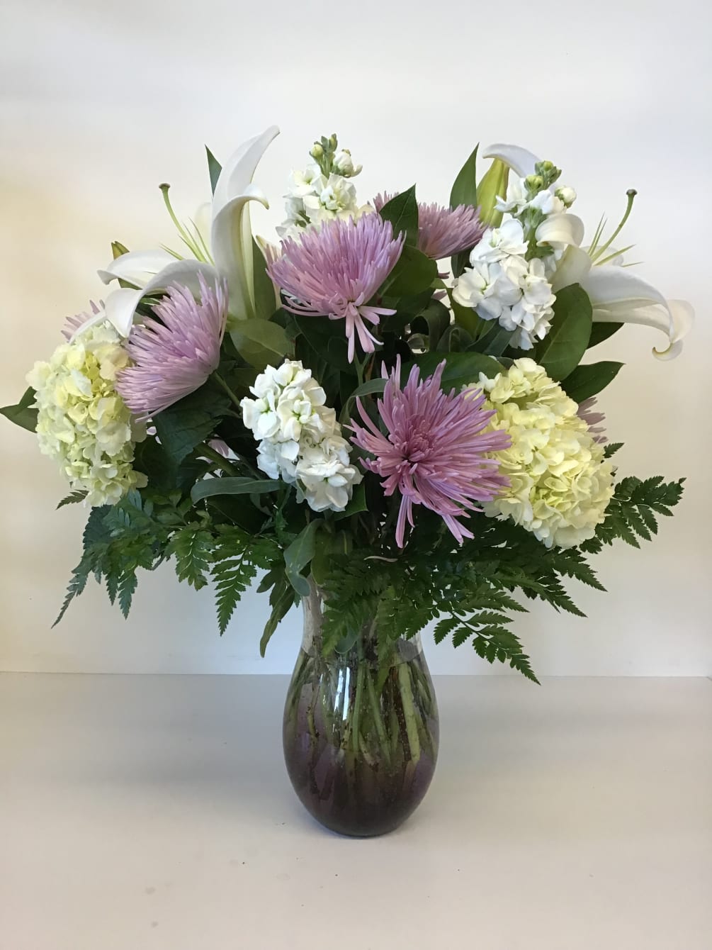 In this arrangement white stargazer lilies, Hydrangea, Stock and Fuji moms have