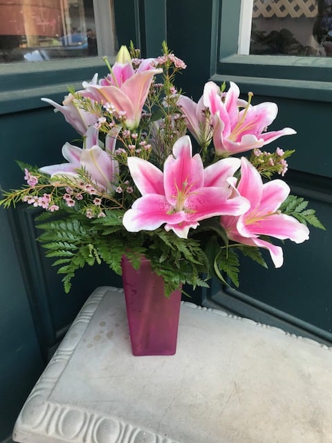 Stargazer Lily, Wax Flower And Greens In A Pink Glass Vase.