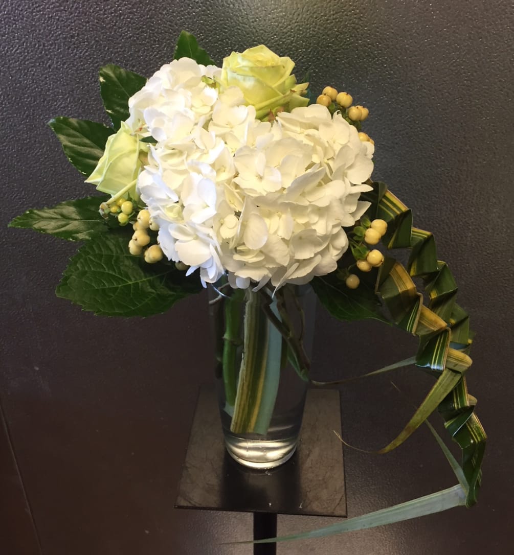 This arrangement screams simplicity and sophistication,
The tall, clear, glass vase is topped