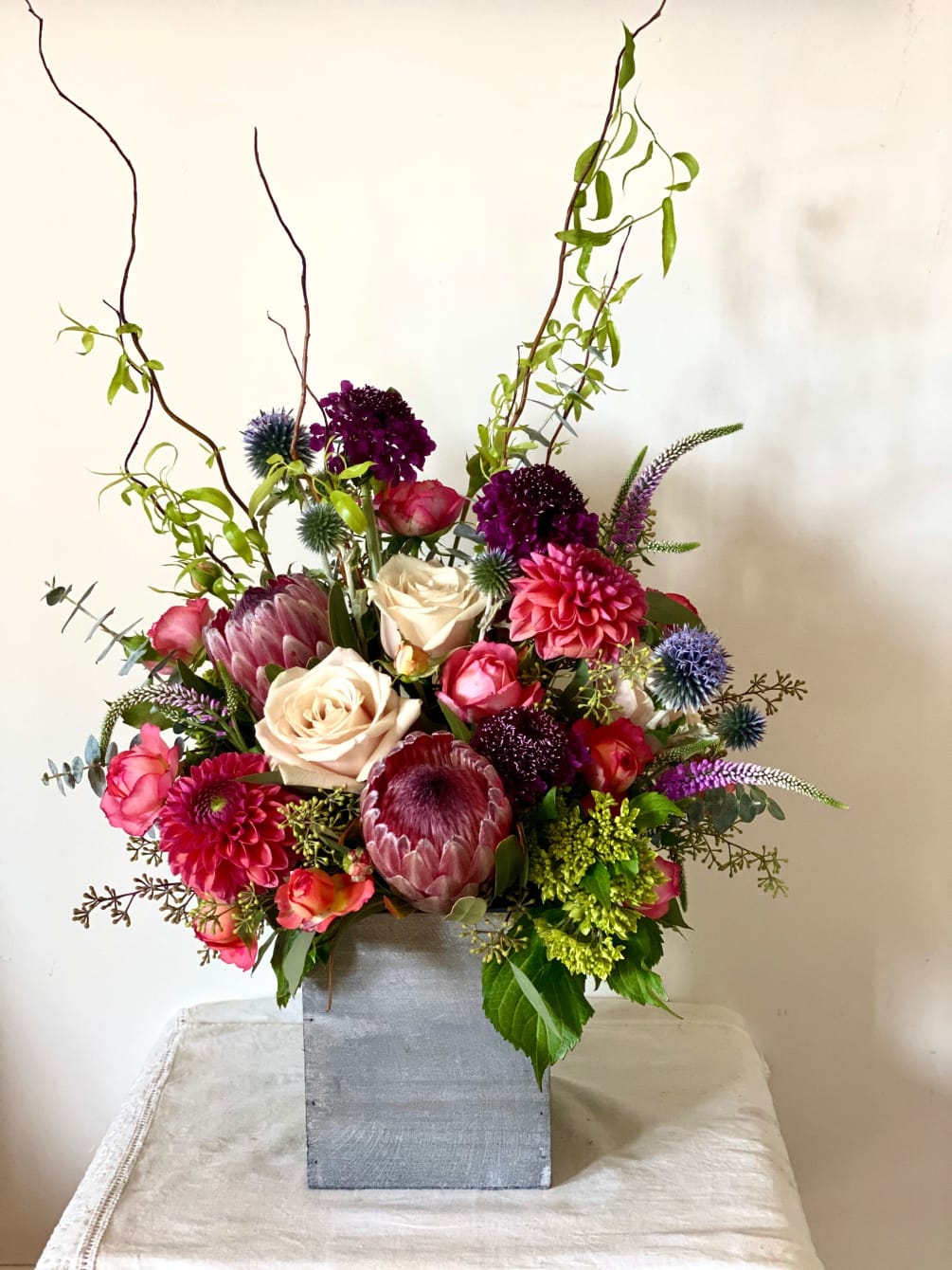 A collection of unique in season blooms, including protea, curly willow, scabiosa