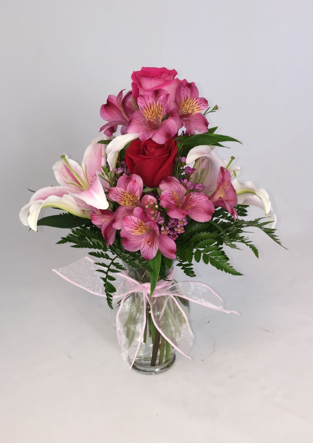 Pink Lillies, Pink Alstromaria, Pink Roses, and wax flower beautifully arranged in