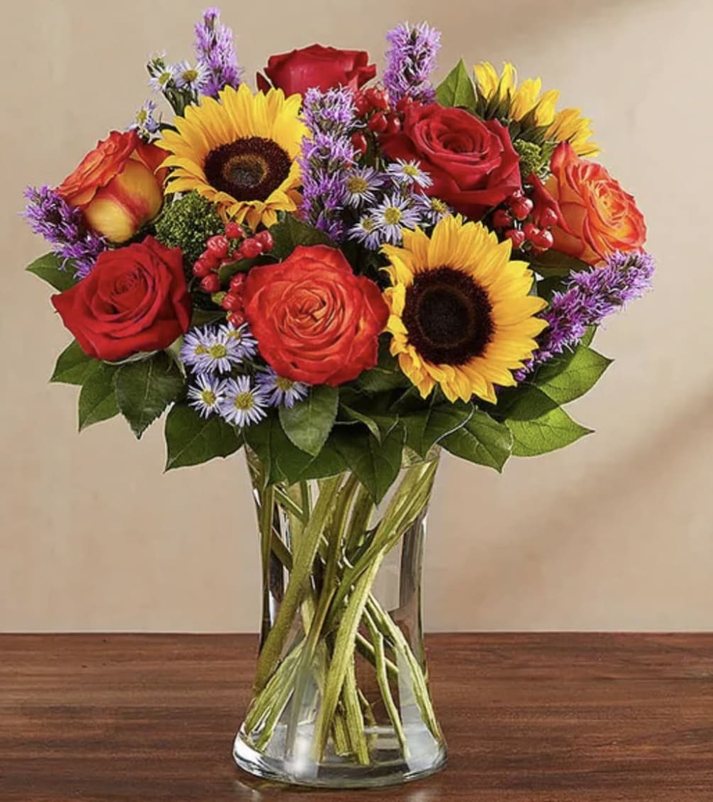 All-around arrangement with red roses and hypericum, autumn-colored roses, sunflowers, purple liatris