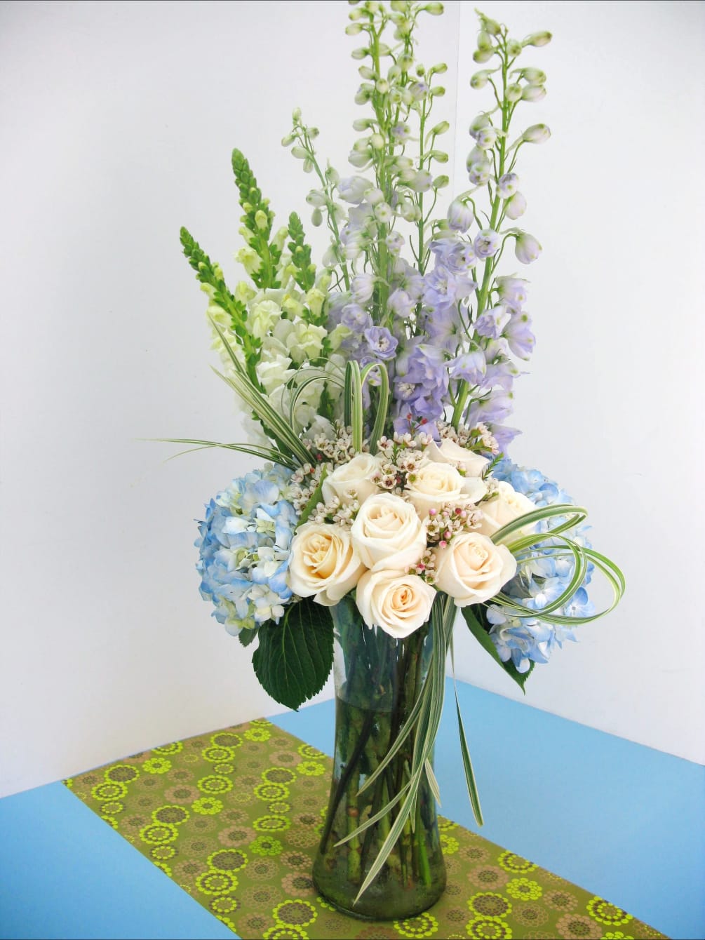 Unique arrangement with white and blue flowers arranged in a clear vase.