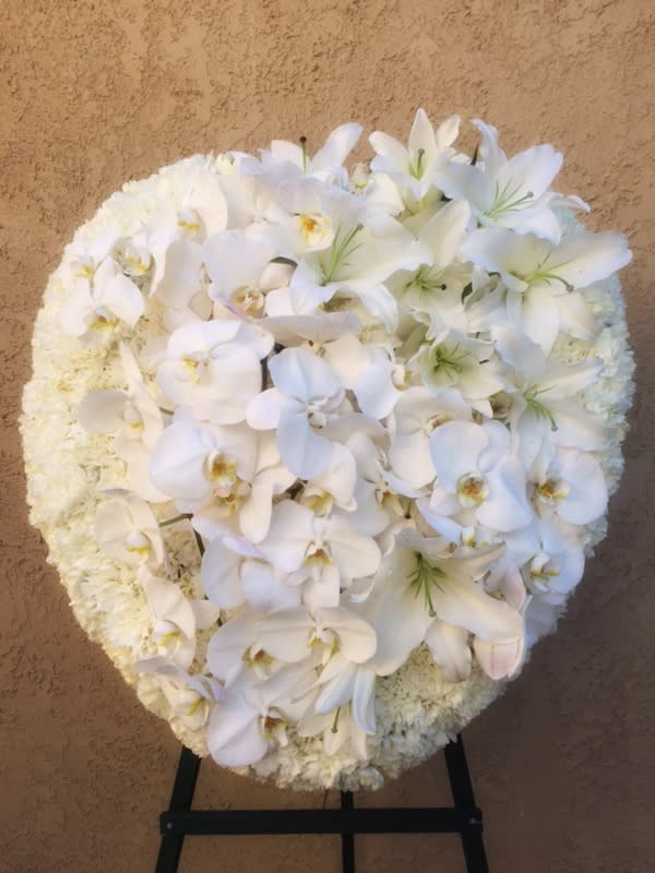 Funeral heart-shaped spray of all white premium flowers including orchid, lily...