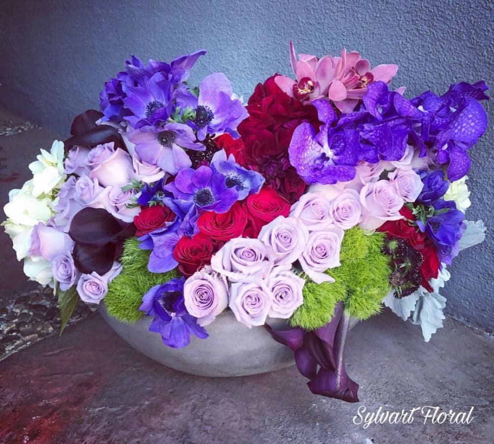 This masterpiece includes, Roses, Calla, Orchids, Dahlias, Hydrangeas, Anemone, Dianthus, Dusty Miller