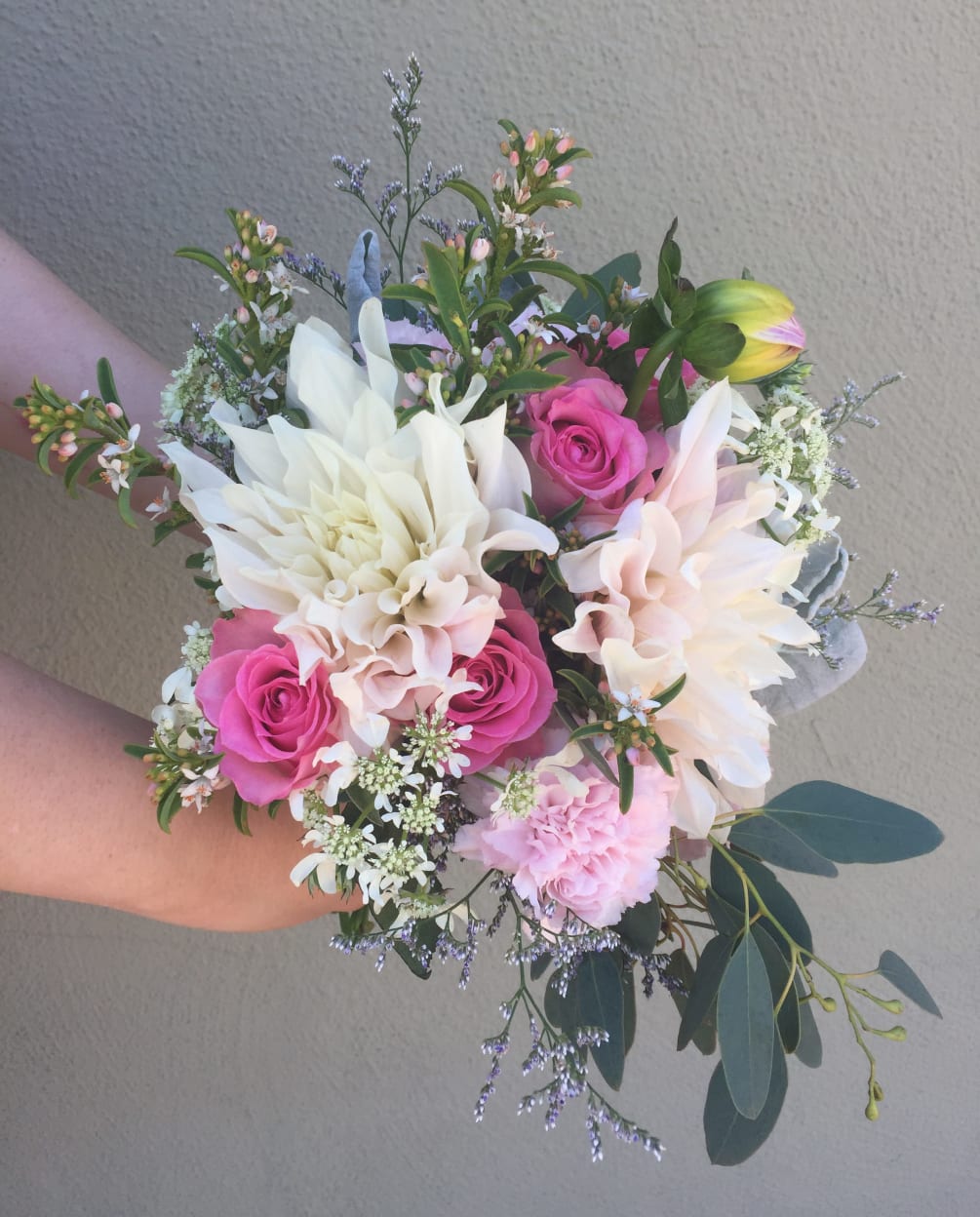 This spring bridal handtied bouquet with Dahlias, roses, carnations, greenery and filler
