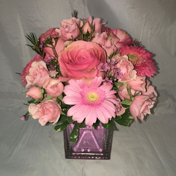 In a 4&quot; baby girl glass cube with pink spray roses, pink