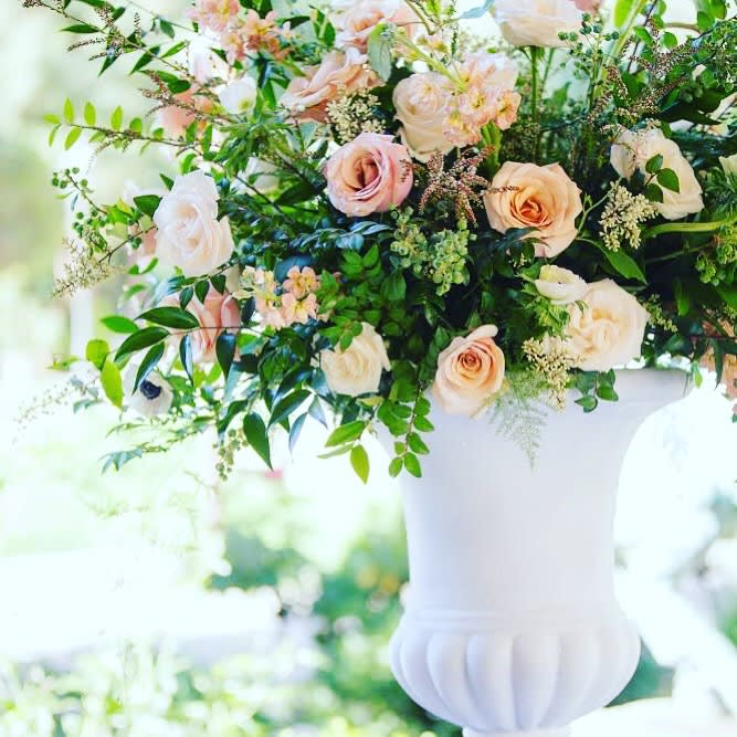 This extravagant centerpiece filled with roses, ranunculus, and greens depicts the fresh
