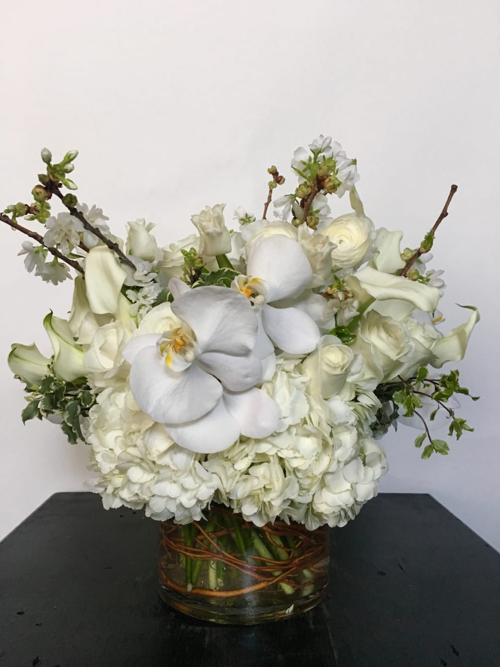 Lush arrangement of seasonal white flowers and blooming branches all based on