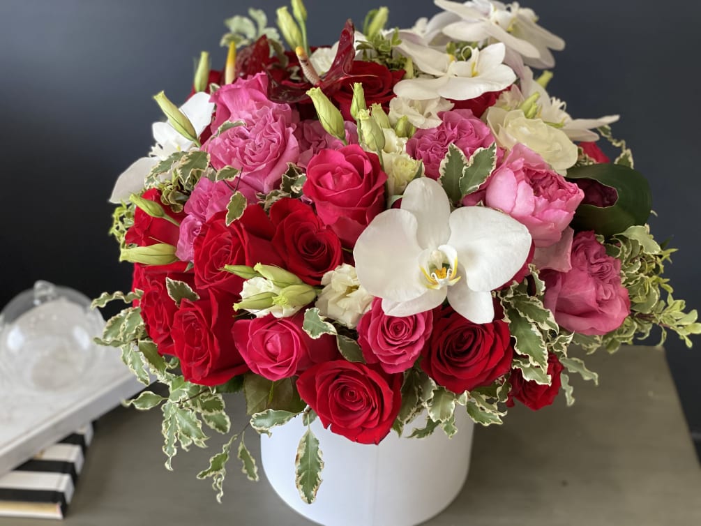 Hat Box arrangement with white, hot pink, and red roses, orchids, and