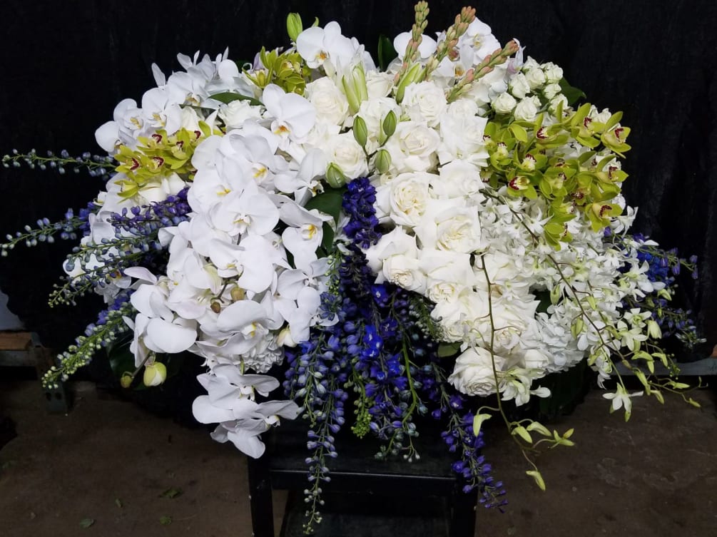 Beautiful casket cover of white roses and lilies, delphinium, dendrobium, phalaenopsis and