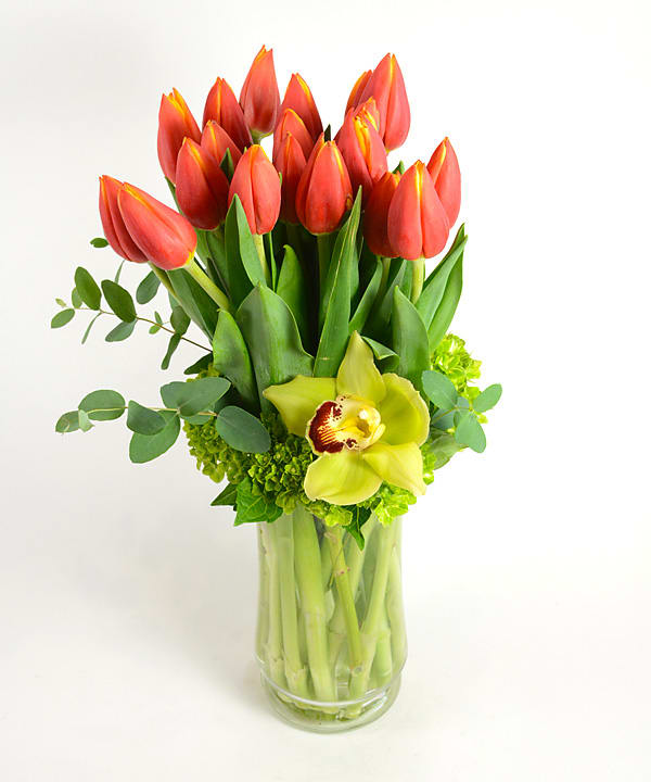 Vivid orange tulips accented with hydrangea and orchid. 