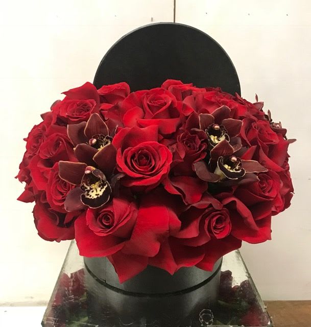 Inside a chic black box, this stunning arrangement is filled with red
