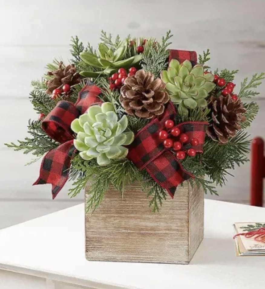 A rustic wood box filled with Winter greenery, berries and succulents. The