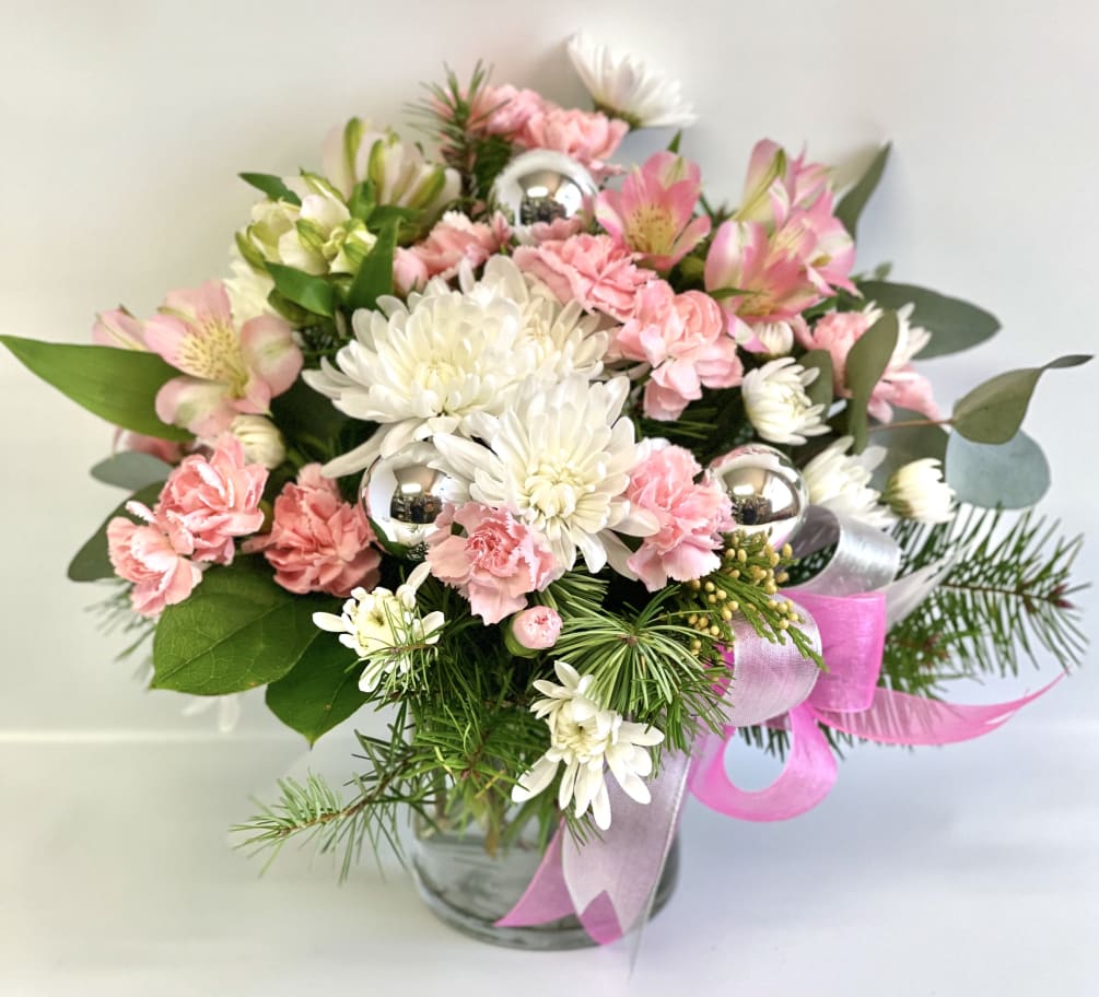 A clear glass cylinder filled with Pink and White flowers. Mums, Carnations