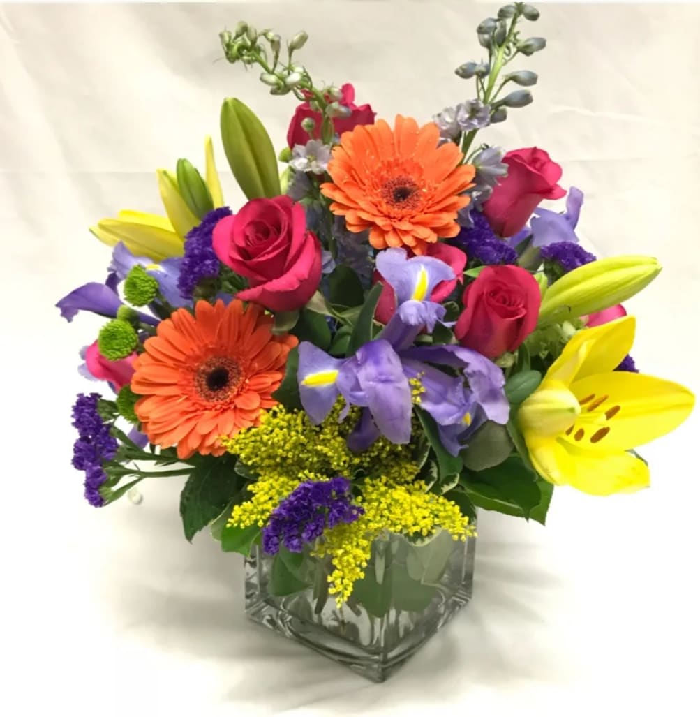 BRIGHT AND COLORFUL MIXED FLORAL ARRANGEMENT IN CLEAR GLASS CUBE VASE BY