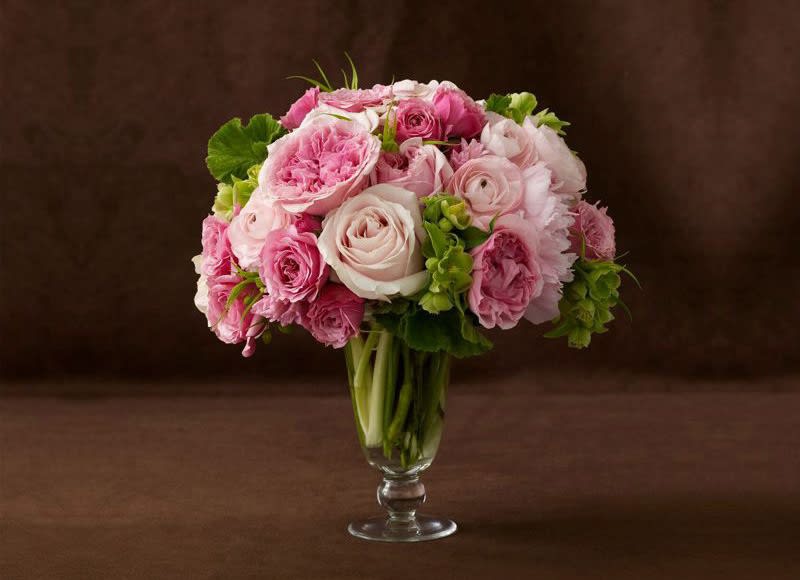 Roses in various shades of pink accompanied by spray roses with green