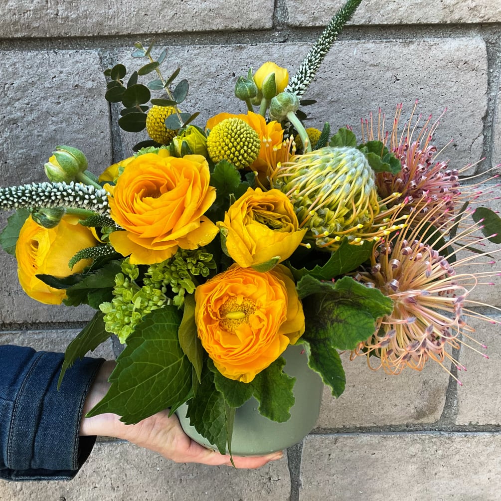 A bright and joyous mix of gold Ranunculus, mini green Hydrangea and
