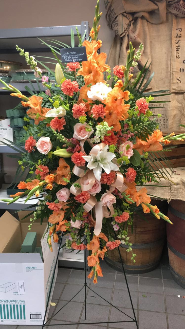 Orange Gladiolas, accented with pink roses, snapdragons and other fresh seasonal flowers