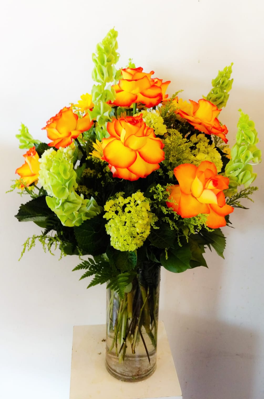 Festive fall flowers, arranged in a 5&quot;x12&quot; cylinder vase.