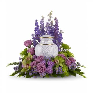 A subdued assortment of flowers such as lavender larkspur, roses and asters