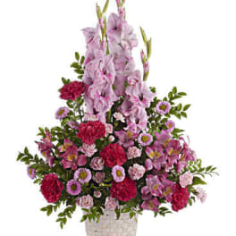 Angelic pink blooms in a white wicker basket create a beautiful sympathy